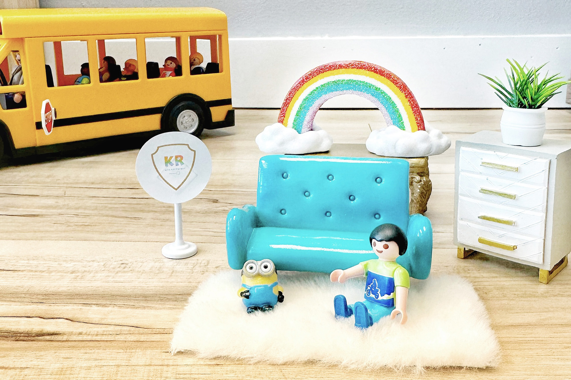Toys arranged to depict a child in a Kids Reconnect play therapy room, with a toy school bus in the background.