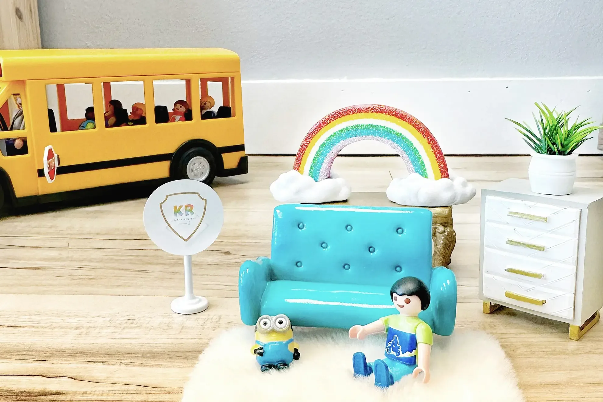 Toys arranged to depict a child in a Kids Reconnect play therapy room, with a toy school bus in the background.