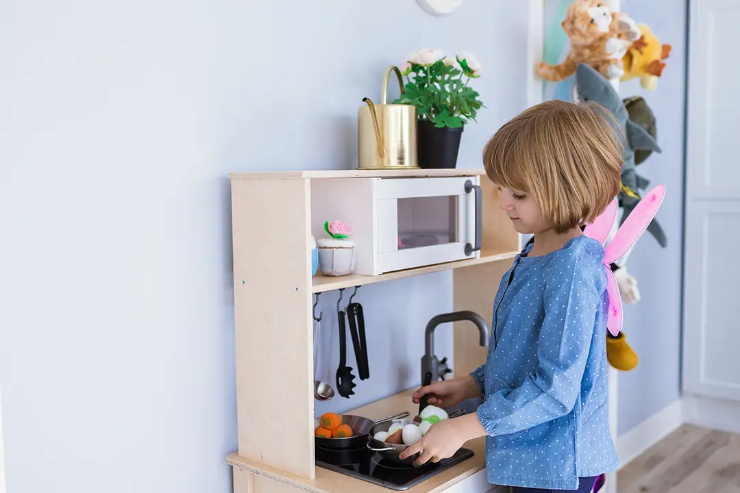 A girl playing in a toy kitchen