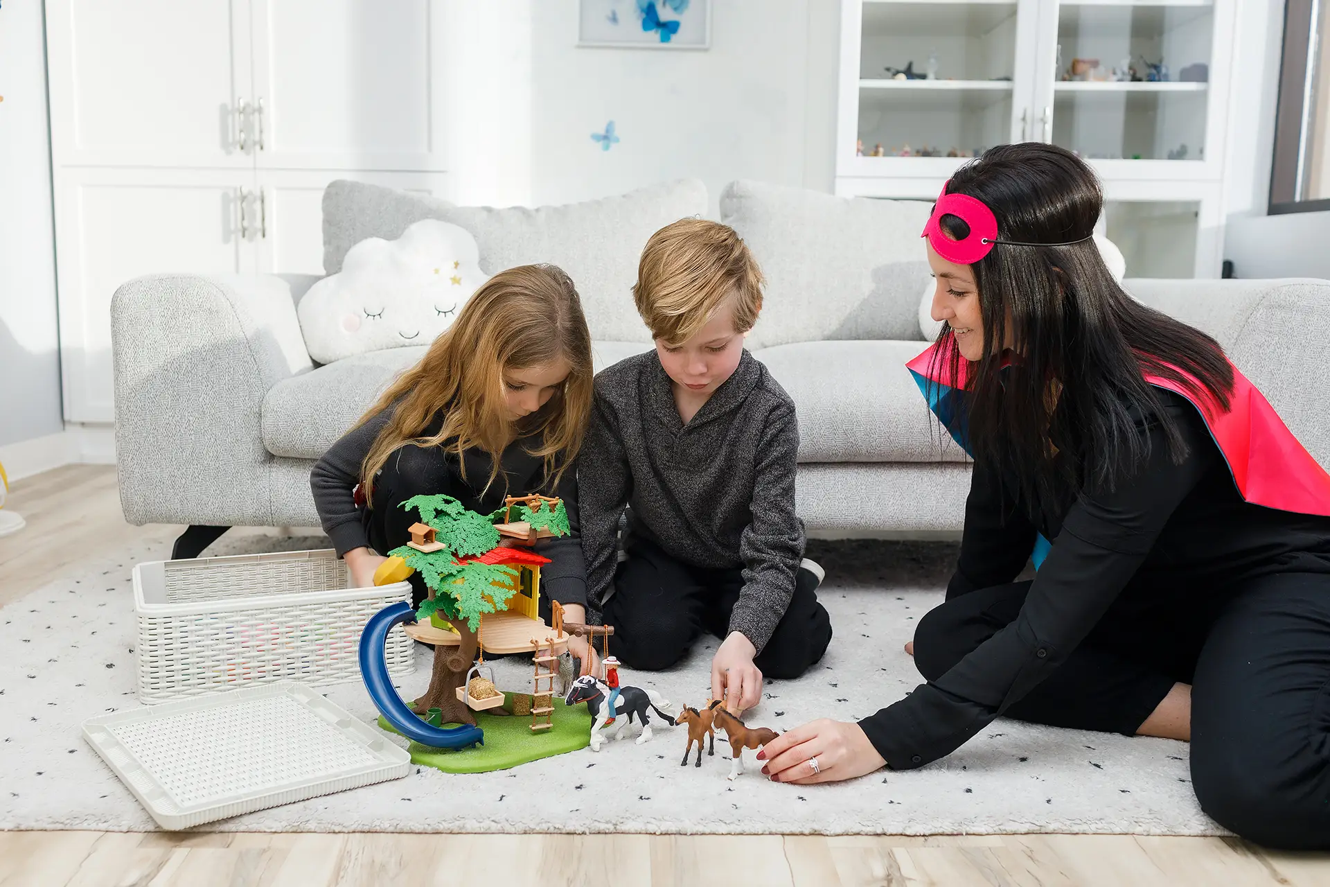 In a play therapy session at Kids Reconnect, a boy holds up a turtle puppet, a girl holds up a cat puppet, and a child therapist holds up an owl puppet.