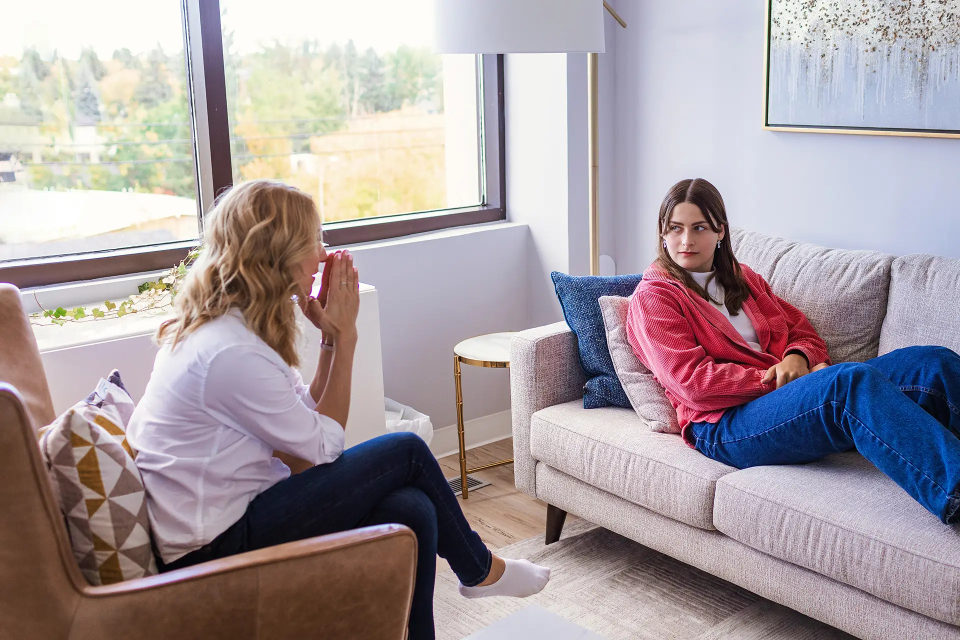 A teen in a therapy session listening to her thrapists.